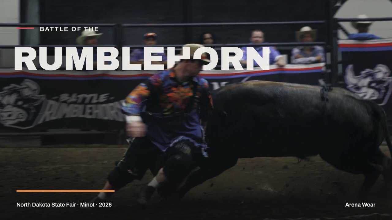A bullfighter takes a black bull shoulder-first under the Battle of the Rumblehorn title